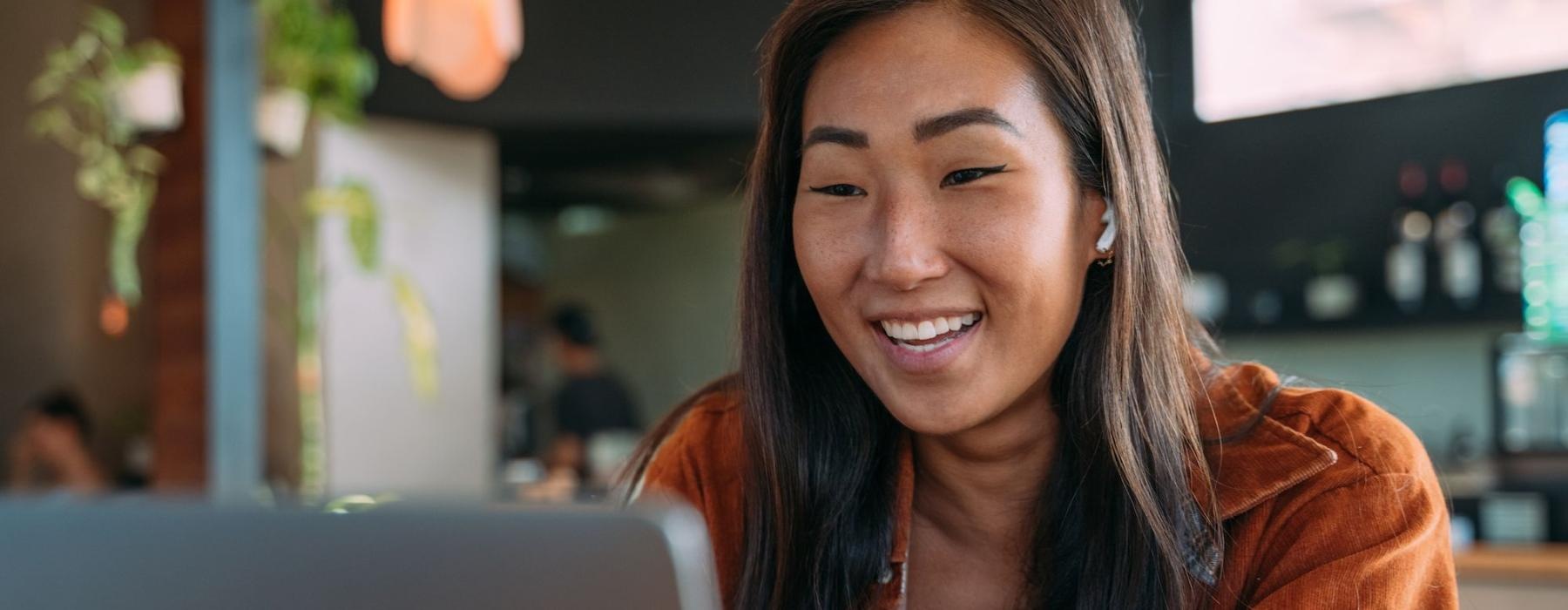 a woman smiling while working on laptop